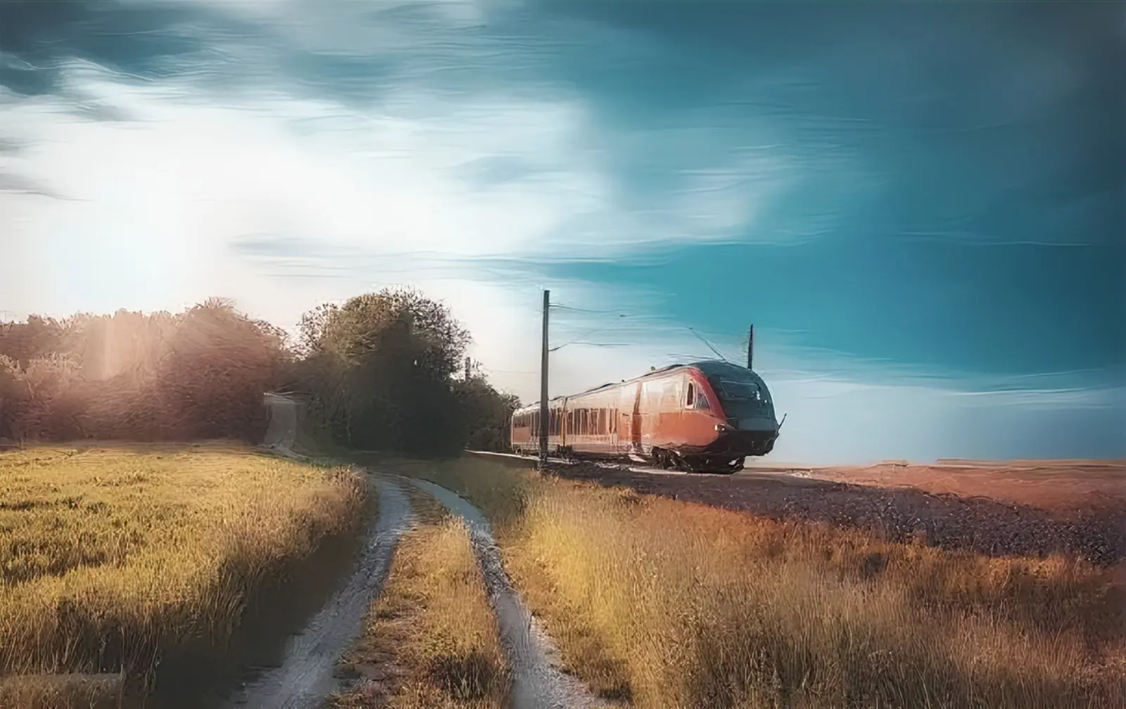 Train rouge roulant à travers une campagne verdoyante sous un ciel bleu, symbolisant la mobilité durable en milieu rural.